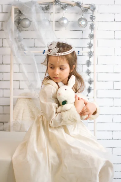 Girl in winter holiday dress with toy rabbit — Stock Photo, Image