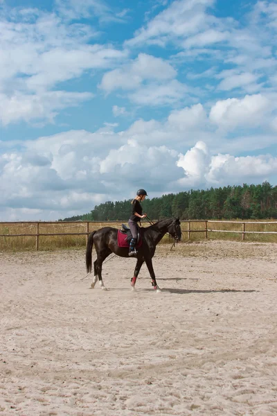 Menina aprendendo a montar cavalo — Fotografia de Stock