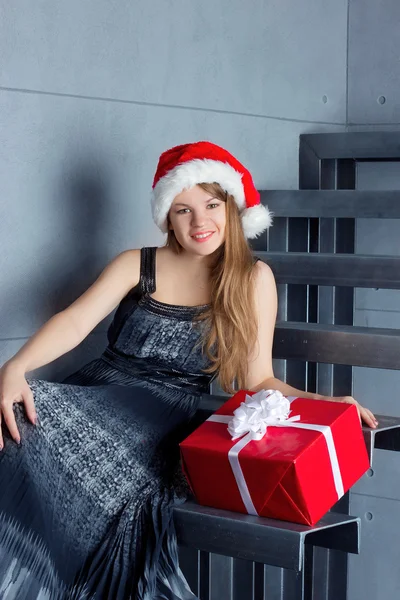 Woman with a present sitting on the stairs — Stock Photo, Image