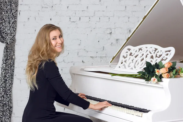 Jeune femme jouant du piano blanc — Photo