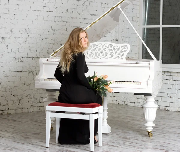 Jeune femme jouant du piano blanc — Photo