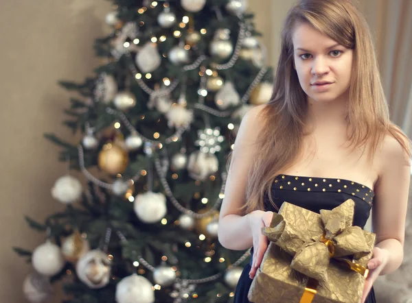 Mujer con caja de regalo y árbol de Navidad — Foto de Stock