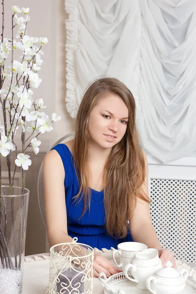 Girl dress sits at table in cosy cafe. — Stock Photo, Image