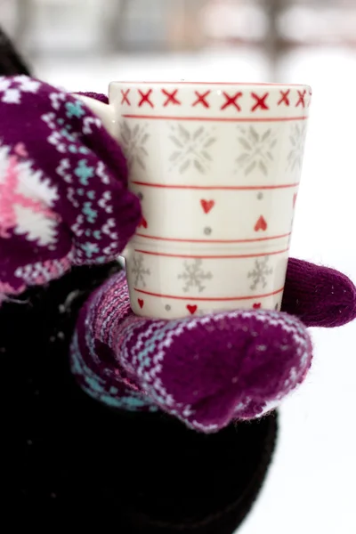 Cozy red gloves hold a mug — Stock Photo, Image