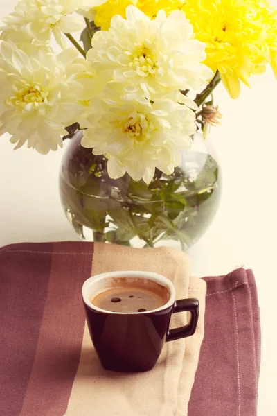 Schwarzer Kaffee in der Nähe der gelben Blumen — Stockfoto