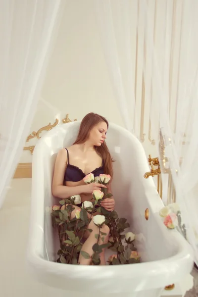 Fille couchée dans la salle de bain avec des roses — Photo