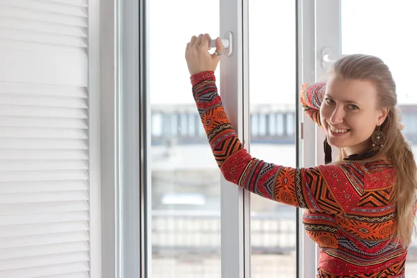 Frau öffnet ein Plastikfenster — Stockfoto