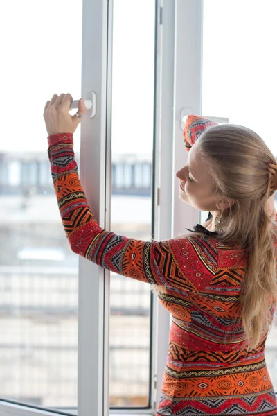 Жінка відкриває пластикове вікно — стокове фото