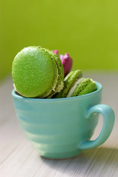 Macaroons in cup on wooden table — Stock Photo, Image