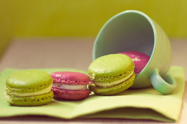 Macaroons in cup on wooden table — Stock Photo, Image