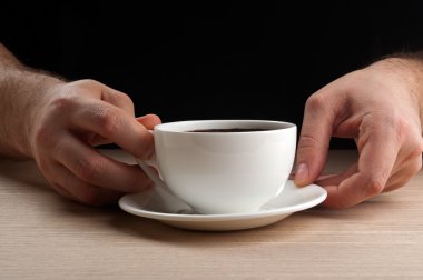 Elinde kahve tutan adam.