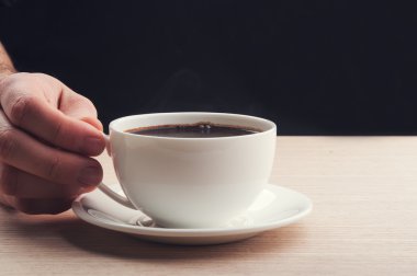 Elinde kahve tutan adam.