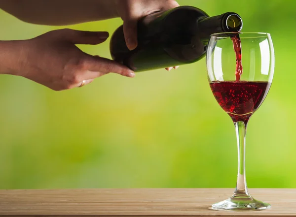 Женщина наливает красное вино — стоковое фото