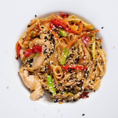 Beyaz tabakta biber, tavuk ve havuçlu Tayland yemeği. Asya lokantası yemeği. Üst görünüm.