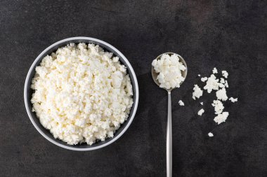 Kâsede taze süzme peynir. Taş masa arka planı. Süt ürünü. Üst görünüm.