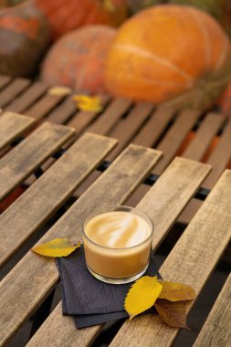 Ahşap bir masada bir fincan lezzetli kahve, arka planda balkabakları. Şükran Günü konsepti.