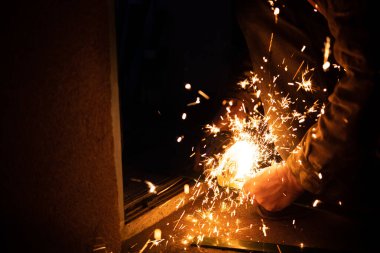 Öğütücüyle metal kesen işçiler ve kıvılcımlar