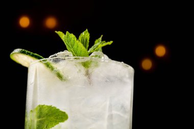 Siyah arka planda izole edilmiş naneli ve limonlu mojito kokteyli.