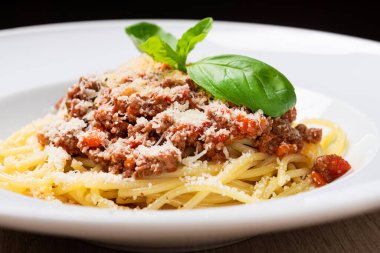 Beyaz tabakta fesleğenli ve peynirli makarna. Yakın plan İtalyan akşam yemeği geçmişi.