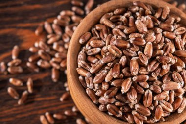 Tahta kaplarda çiğ buğday taneleri. tohum arka planı.