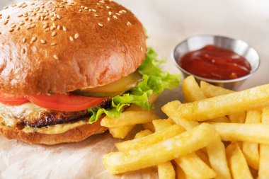 Hamburger, patates kızartması ve ketçaplı fast food. Zararlı ve yağlı yemek geçmişi.