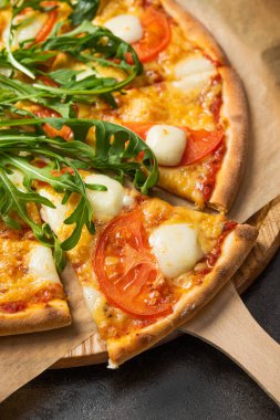 Yeşil roka salatalı pizza margaritası. Popüler İtalyan yemekleri ve fast food.
