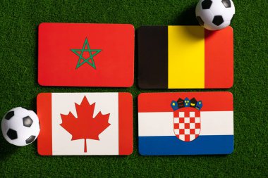Katar 'da dünya futbol şampiyonu. F Grubu rozetleri Fas, Kanada, Belçika ve Hırvatistan milli takımlarını temsil ediyor. Sahada üst görünüm ve yandan klasik toplar.