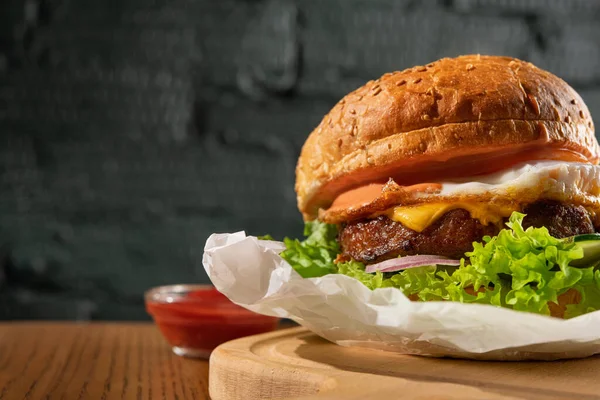 Burger Jajkiem Kotletem Restauracji Stole Tle Ciemnej Cegły — Zdjęcie stockowe