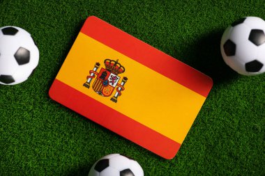 Flag of Spain. Football balls on a green lawn. World Cup 2022. Top view.