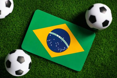Flag of Brazil. Football balls on a green lawn. World Cup 2022. Top view.