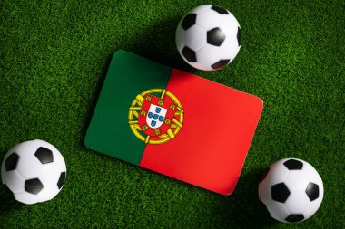 Flag of Portugal. Football balls on a green lawn. World Cup 2022. Top view.