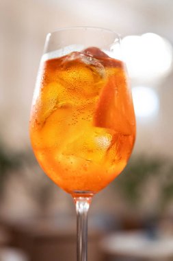 Closeup of aperol spritz cocktail in a restaurant background.