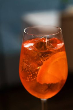 Closeup of aperol spritz cocktail in a restaurant background.