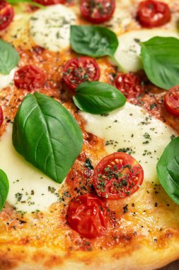 Italian pizza Margherita with basil leaves, fresh tomato and mozzarella cheese. vegetarian food background.