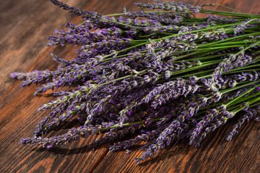 A bouquet of fresh lavender flowers on a wooden table. Summer background flora.
