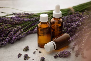 Production of perfumes from lavender. Cosmetologist's office. Oil and flowers on a stone table background.