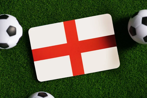 Flag of England. Football balls on a green lawn. World Cup 2022. Top view.