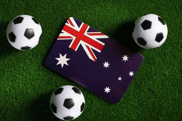 Flag of Australia. Football balls on a green lawn. World Cup 2022. Top view.
