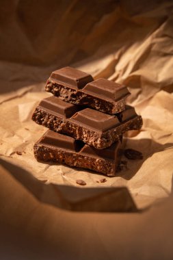 Kraft kağıdında çikolata parçaları. Sıcak ışık kavramı arkaplanı.