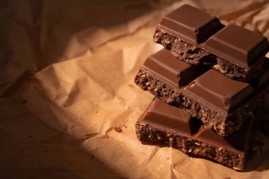 Kraft kağıdında çikolata parçaları. Sıcak ışık kavramı arkaplanı.