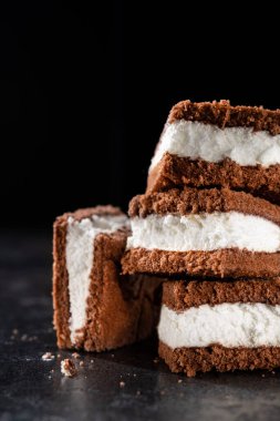 Koyu arkaplanda lezzetli çikolatalı bisküvi keki. Kremalı tatlı..