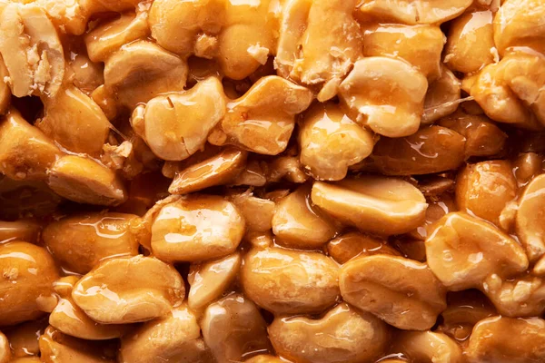 Sweet peanut bar caramelized glaze on a background. energy fast food. Closeup. Macro.