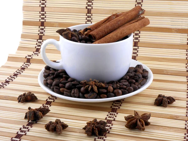 Bílý hrnek s kávou a skořicí poblíž hvězdy anis bambusový stůl — Stock fotografie