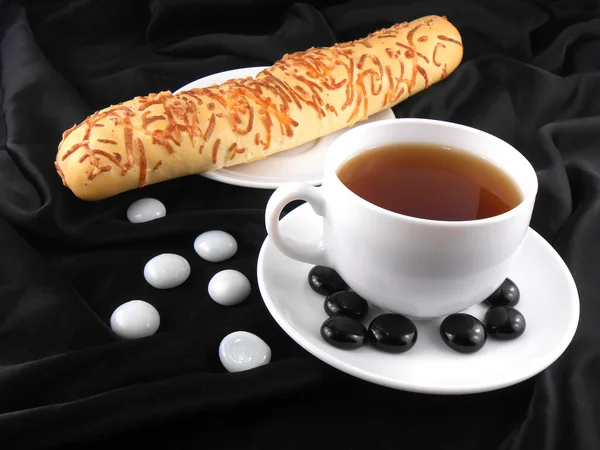 Caffè caldo con pane e pietre su sfondo nero — Foto Stock