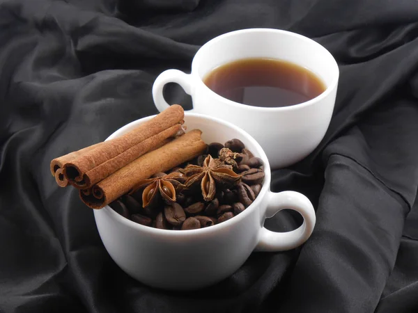 Hvit kopp te, kaffebønner, kanel og stjerneanis – stockfoto