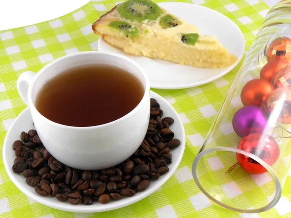 Christmas decoration with cup of coffee, coffee beans and sweet kiwi cake — Stock Photo, Image