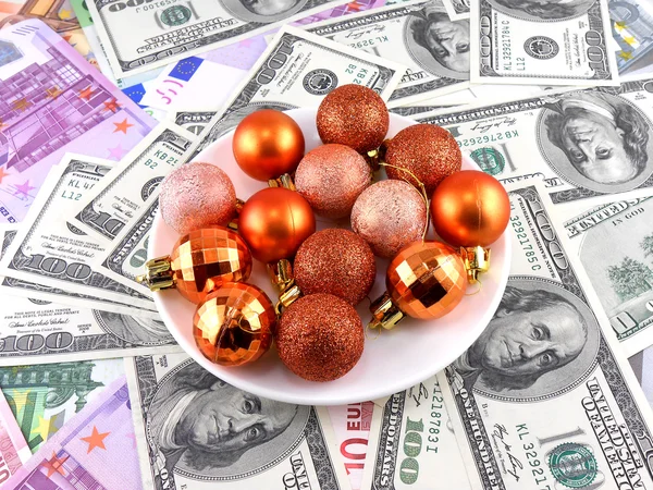 Christmas balls set on white plate, dollar background — Stock Photo, Image