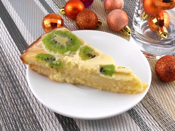Kiwi tasty cake with champagne wine bottle and christmas balls — Stock Photo, Image