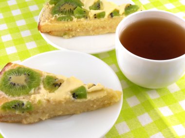 bir fincan çay ve meyve ile lezzetli kremalı pastadan bir parça