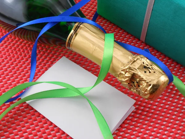 Bottle of a champagne and green gift boxes — Stock Photo, Image